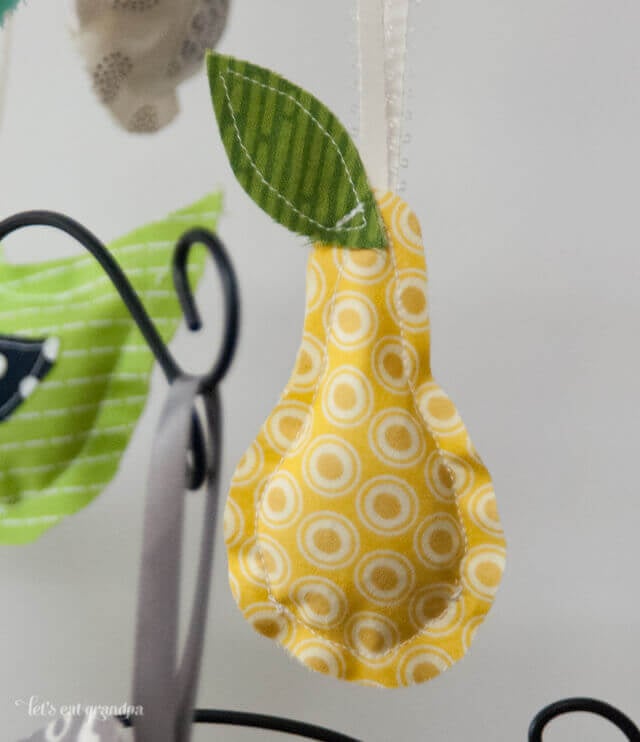 finished pear fabric ornament hanging from mini branch