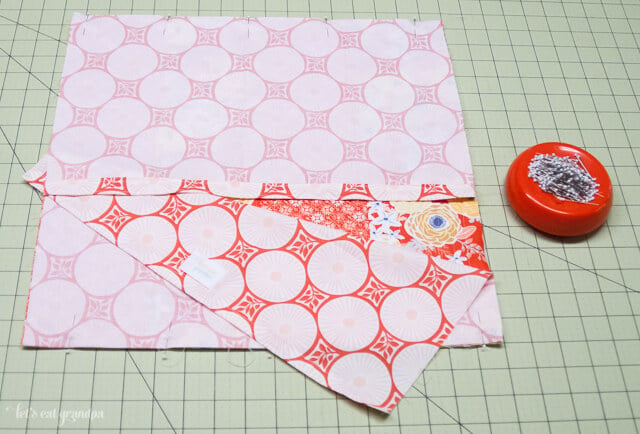 Fabric on cutting mat with other fabric on top to make pillow envelope closure
