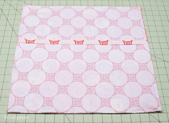 Fabric on cutting mat with other fabric on top to make pillow envelope closure