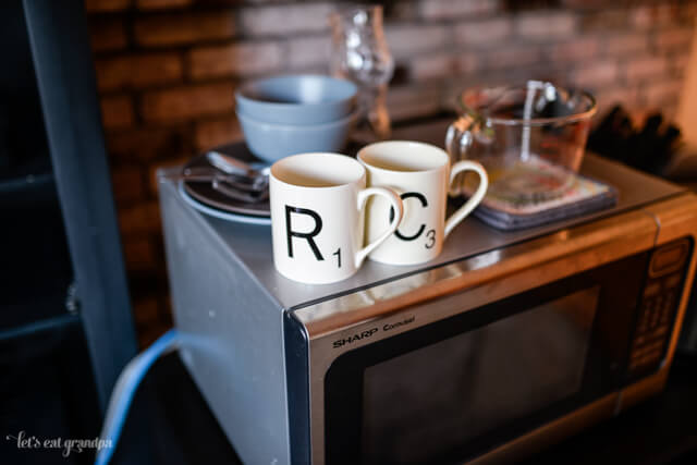 temporary kitchen set up in living room - coffee mugs on microwave