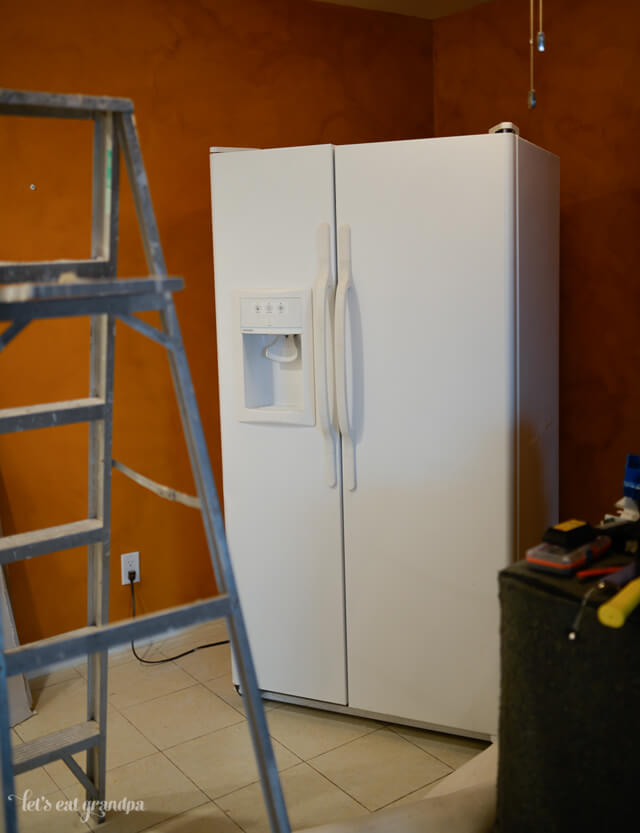 refrigerator in garage with lladder blcoking it