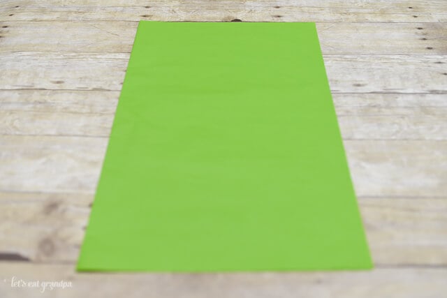 green tissue paper sheet on wooden background