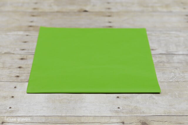 green tissue paper sheet on wooden background, horizontal