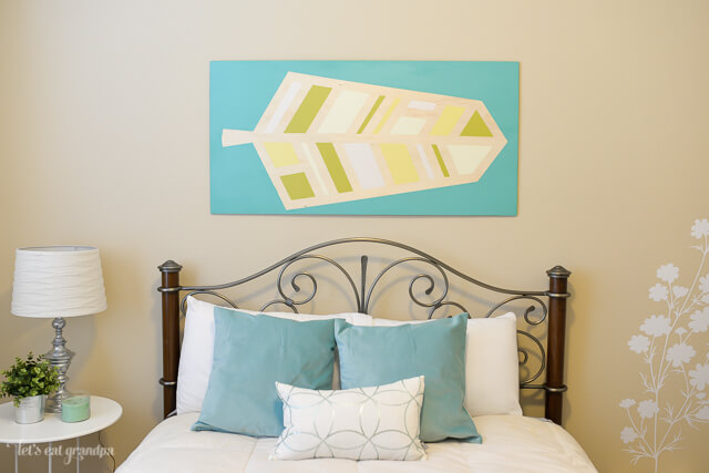 pretty bed in guest room makeover with wall art above bed