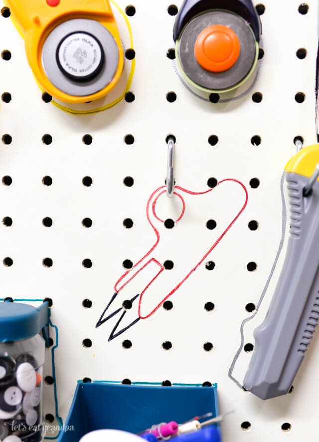 craft tools hanging from pegboard with colorful sharpie outline behind them