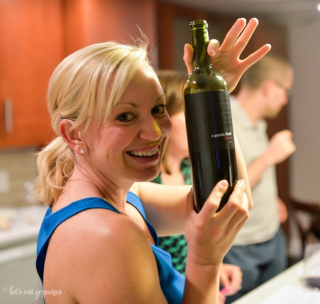 woman holding up bottle of red wine