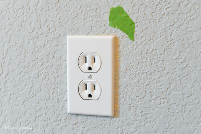 wall outlet with green painter's tape on wall