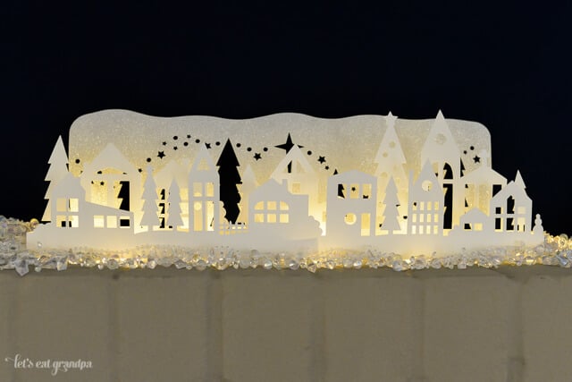 This gorgeous winter wonderland luminaria is a beautiful decoration on your Christmas mantel or table! Cut using your Cricut or other cutting machine and add fairy lights so it glows!